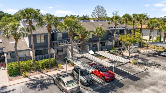 exterior space featuring stairway and covered and uncovered parking