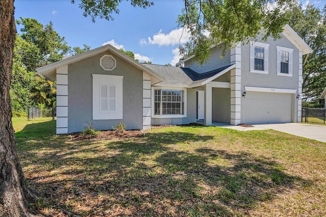 view of front facade with fence, concrete driveway, an attached garage, stucco siding, and a front yard
