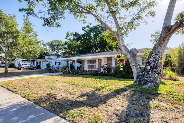 4243 Maceachen Blvd, Sarasota, FL 34233 - ranch-style home featuring a front yard, brick siding, a carport, and driveway