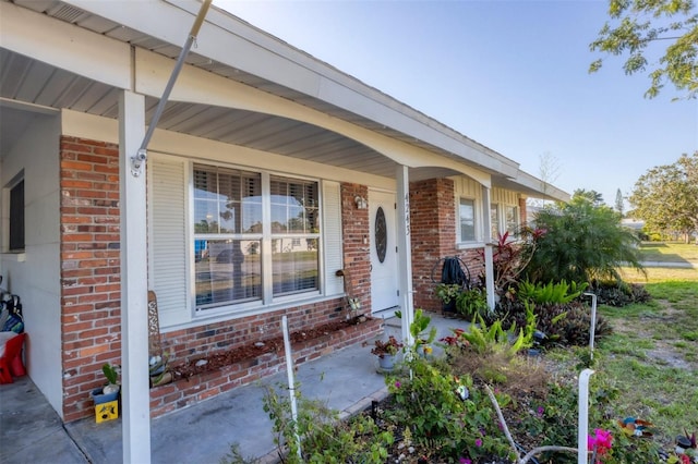 4243 Maceachen Blvd, Sarasota, FL 34233 - doorway to property with brick siding and a porch