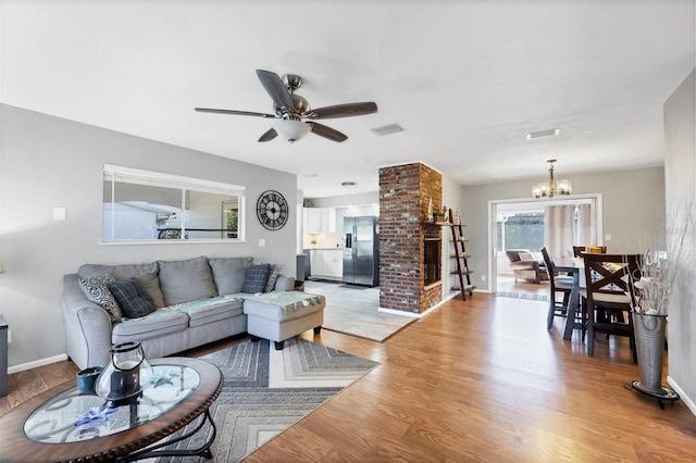 4243 Maceachen Blvd, Sarasota, FL 34233 - living area featuring light wood-style flooring, ceiling fan with notable chandelier, baseboards, and visible vents
