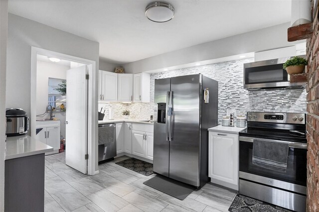 4243 Maceachen Blvd, Sarasota, FL 34233 - kitchen with stainless steel appliances, tasteful backsplash, white cabinets, and light countertops