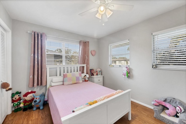 4243 Maceachen Blvd, Sarasota, FL 34233 - bedroom featuring ceiling fan, multiple windows, baseboards, and wood finished floors