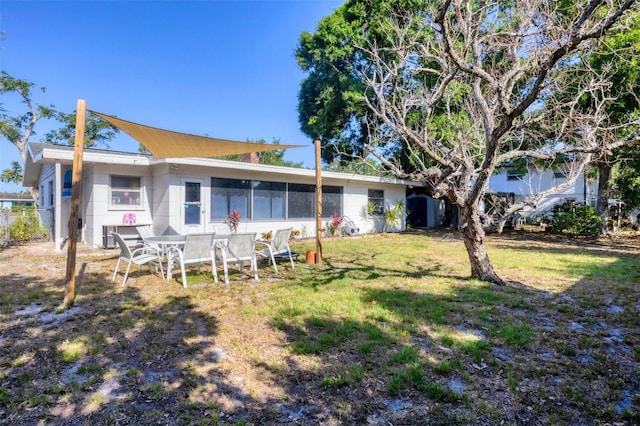 4243 Maceachen Blvd, Sarasota, FL 34233 - rear view of house featuring a sunroom and a lawn