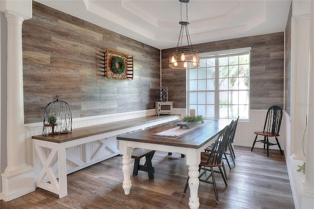 5810 Lake Victoria Dr, Lakeland, FL 33813 - dining room with ornate columns, a chandelier, wood finished floors, a raised ceiling, and wooden walls