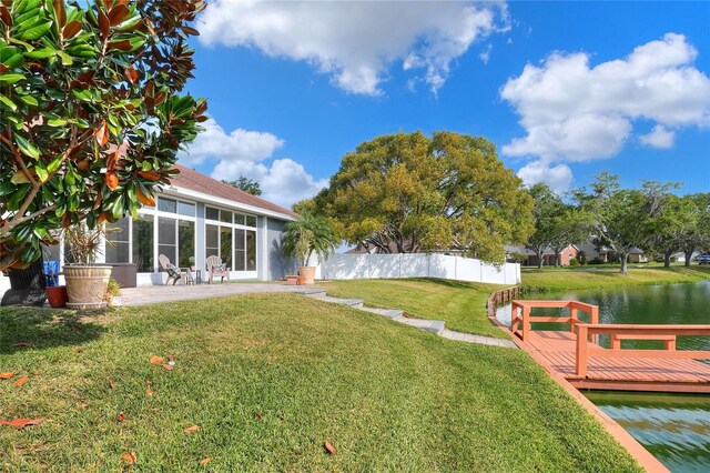 5810 Lake Victoria Dr, Lakeland, FL 33813 - view of yard featuring a sunroom, a water view, a patio, fence, and a boat dock