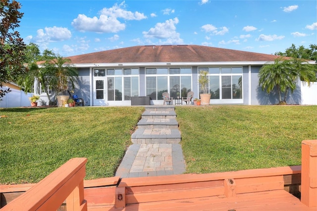 5810 Lake Victoria Dr, Lakeland, FL 33813 - back of house featuring a sunroom, a yard, and stucco siding