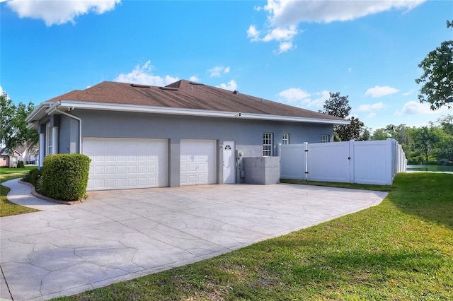 5810 Lake Victoria Dr, Lakeland, FL 33813 - view of side of home featuring stucco siding, driveway, a garage, a gate, and a lawn