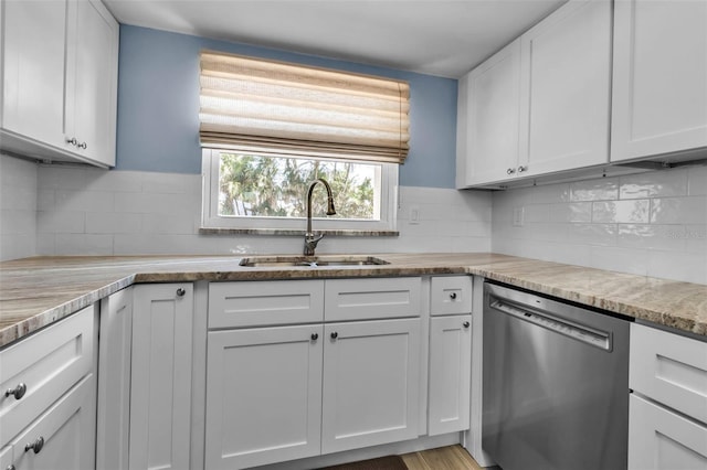 kitchen featuring dishwasher, a sink, white cabinets, and tasteful backsplash