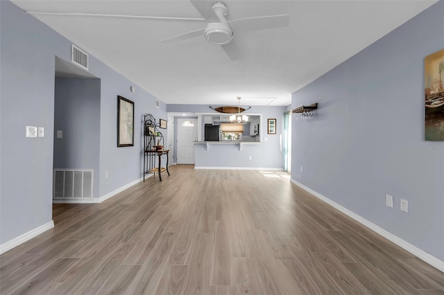 unfurnished living room featuring wood finished floors, ceiling fan, and baseboards