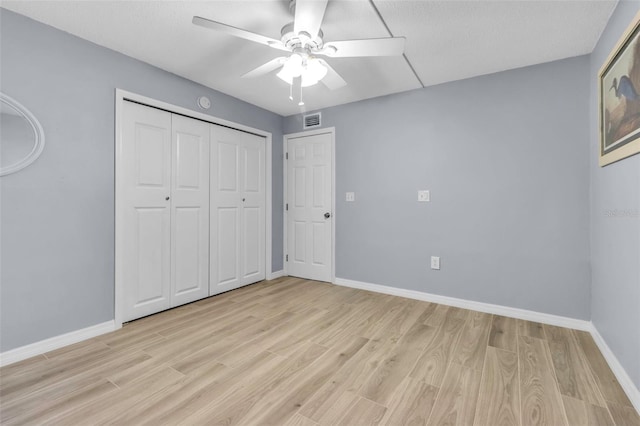 unfurnished bedroom with light wood-type flooring, baseboards, ceiling fan, and a closet