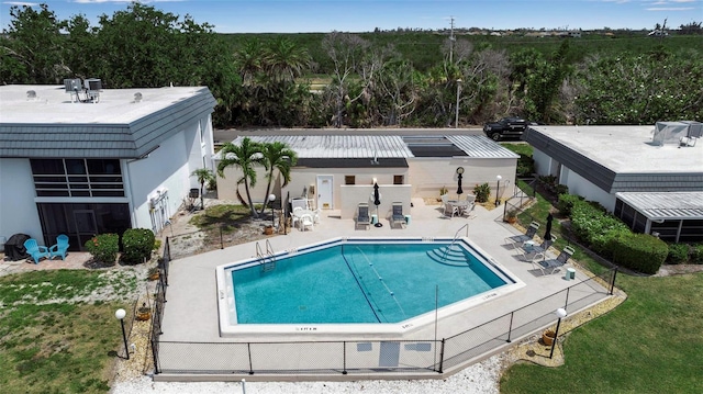 community pool with a patio and fence