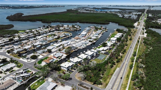 aerial overview of property's location featuring a large body of water, nearby suburban area, and a highway