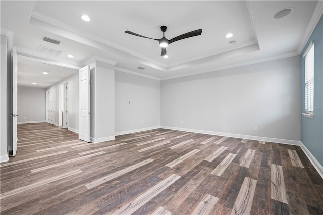 spare room with a ceiling fan, baseboards, wood finished floors, and a tray ceiling