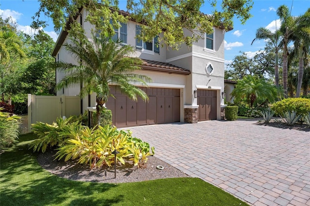 1719 Kenilworth St, Sarasota, FL 34231 - view of front facade featuring a garage, decorative driveway, stucco siding, a tiled roof, and stone siding