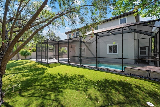 1719 Kenilworth St, Sarasota, FL 34231 - rear view of house with stucco siding, glass enclosure, a yard, and a patio area
