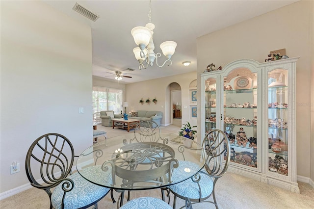 1631 Madison Ave, North Port, FL 34286 - dining area featuring ceiling fan with notable chandelier, arched walkways, visible vents, light carpet, and baseboards