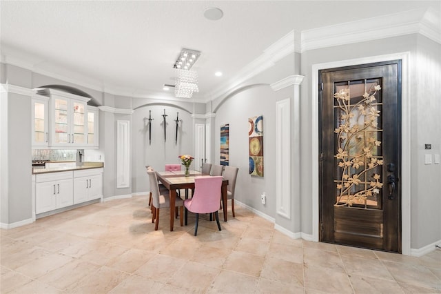 dining area with crown molding, light tile patterned floors, and ornate columns