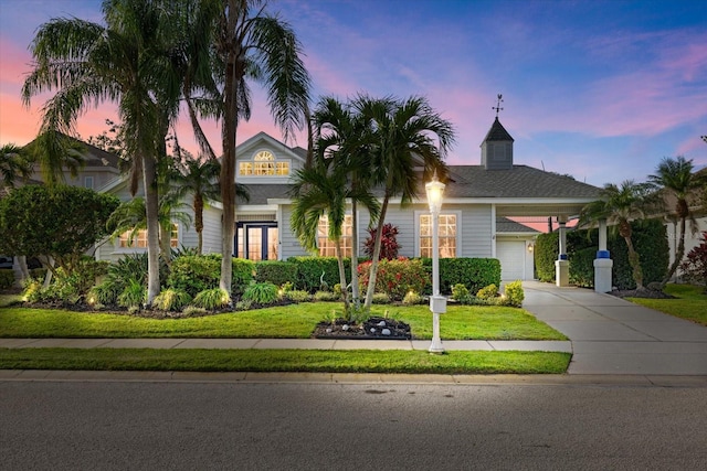 view of front of house featuring a yard, an attached garage, and concrete driveway