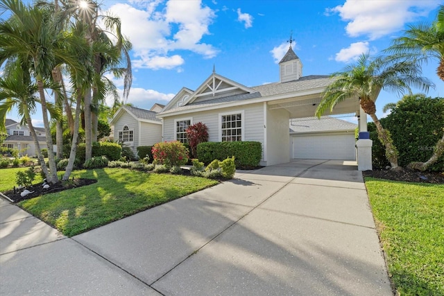 ranch-style home with a front yard, roof with shingles, a garage, and concrete driveway
