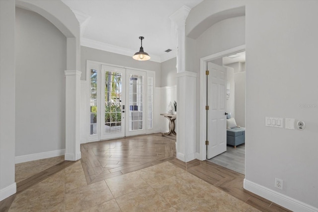 entrance foyer featuring baseboards, french doors, ornate columns, and ornamental molding