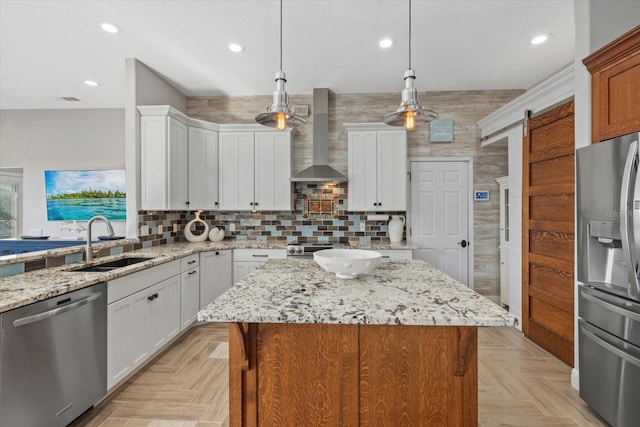 kitchen featuring a sink, wall chimney range hood, recessed lighting, white cabinetry, and stainless steel appliances