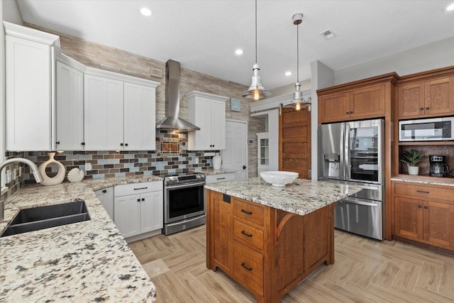 kitchen with wall chimney range hood, visible vents, recessed lighting, appliances with stainless steel finishes, and a sink