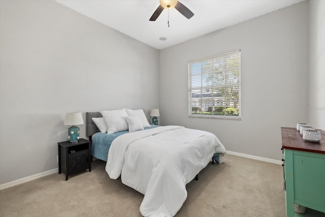 bedroom featuring baseboards, ceiling fan, and light colored carpet