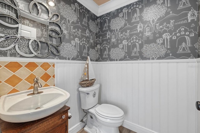 bathroom featuring toilet, vanity, and a wainscoted wall