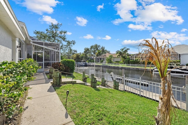 view of yard with a water view, a residential view, a lanai, and a dock