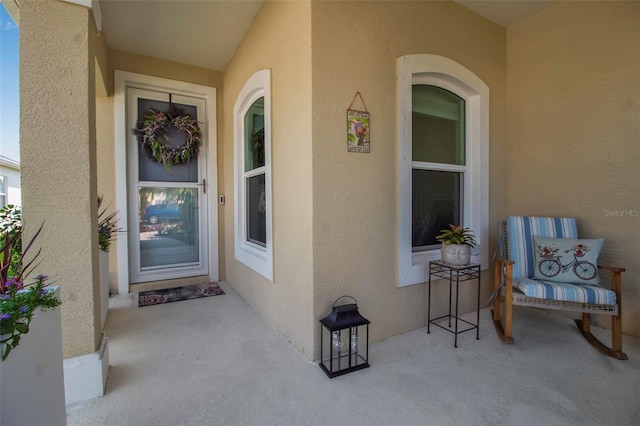 entrance to property featuring stucco siding and a porch