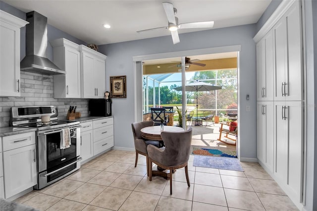 kitchen featuring stainless steel electric range, wall chimney exhaust hood, a sunroom, a ceiling fan, and tasteful backsplash