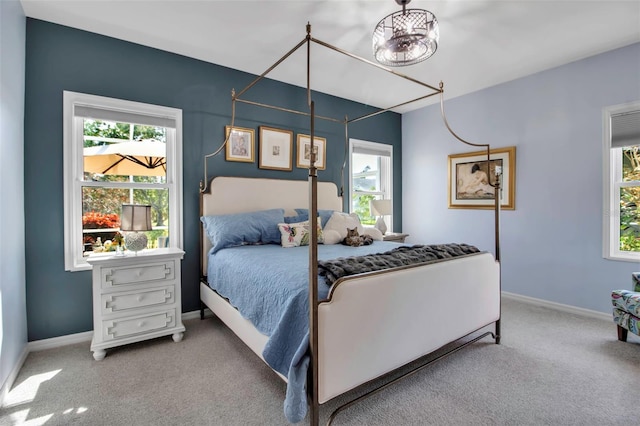 carpeted bedroom featuring multiple windows and baseboards