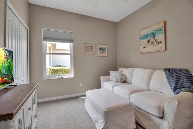 carpeted living area featuring baseboards