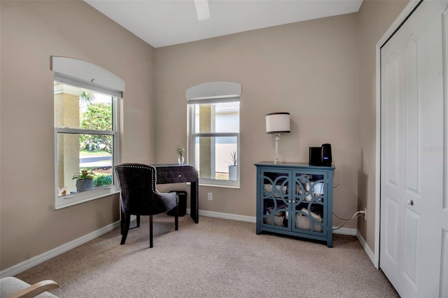 carpeted office space featuring healthy amount of natural light, baseboards, and a ceiling fan