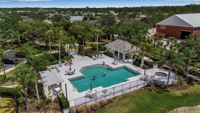 community pool with fence, a patio area, and a hot tub