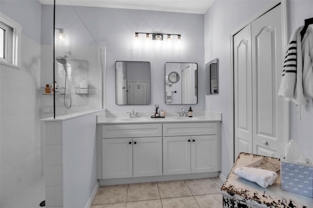 bathroom featuring walk in shower, double vanity, and tile patterned floors