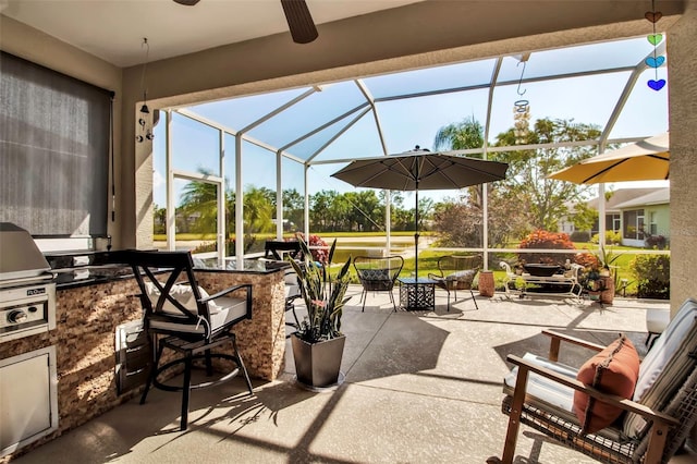 view of patio / terrace featuring area for grilling, glass enclosure, ceiling fan, and a bar