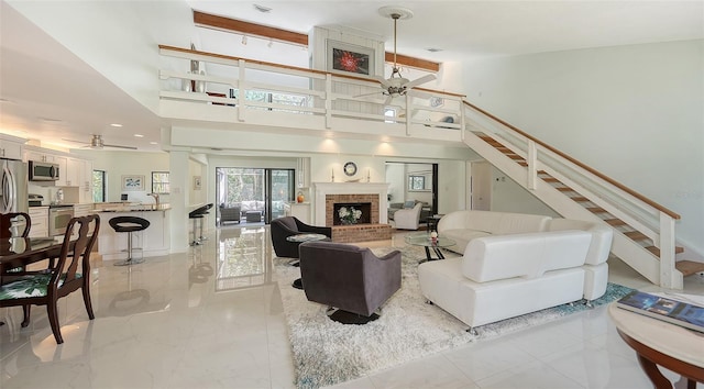 5324 Siesta Ct, Sarasota, FL 34242 - living area with ceiling fan, stairway, a towering ceiling, and a brick fireplace