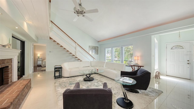 5324 Siesta Ct, Sarasota, FL 34242 - tiled living room with high vaulted ceiling, a ceiling fan, a brick fireplace, and stairs