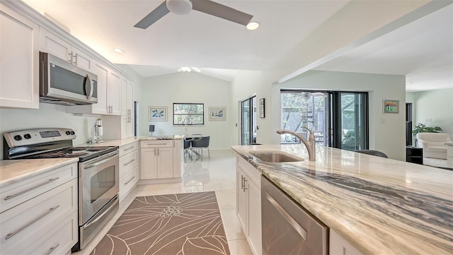5324 Siesta Ct, Sarasota, FL 34242 - kitchen with ceiling fan, light stone countertops, white cabinetry, a sink, and stainless steel appliances