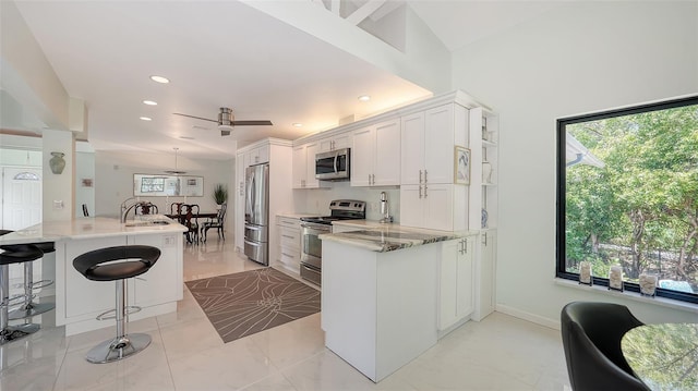 5324 Siesta Ct, Sarasota, FL 34242 - kitchen featuring stainless steel appliances, marble finish floor, white cabinetry, and a sink