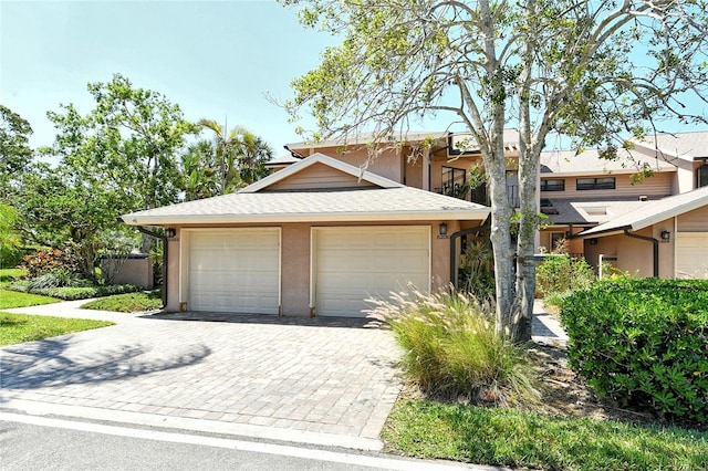 view of front facade featuring a detached garage and stucco siding