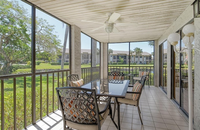 sunroom / solarium featuring a residential view, ceiling fan, and outdoor dining space
