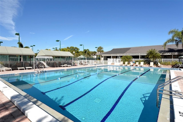 community pool with fence and a patio