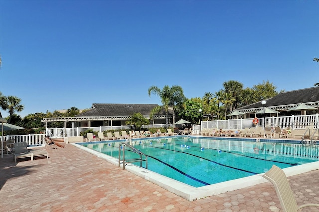 pool with fence and a patio