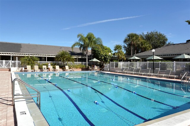 community pool featuring fence and a patio