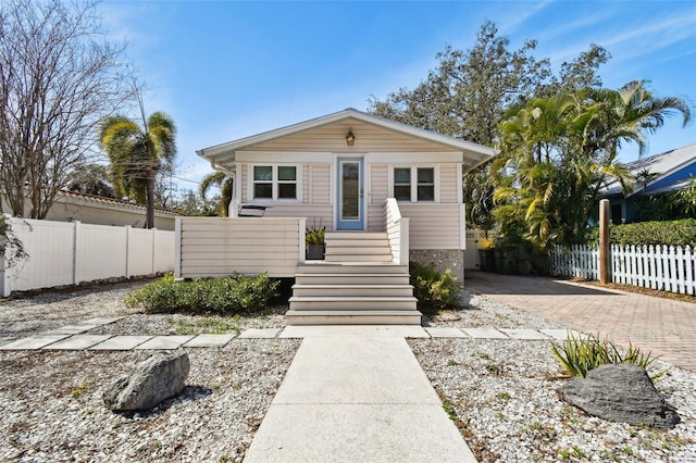 bungalow featuring fence