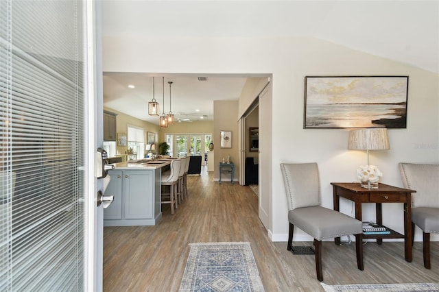 foyer featuring recessed lighting, lofted ceiling, visible vents, baseboards, and light wood-style flooring