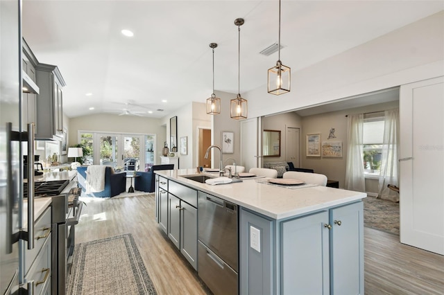 kitchen featuring lofted ceiling, visible vents, gray cabinetry, appliances with stainless steel finishes, and open floor plan